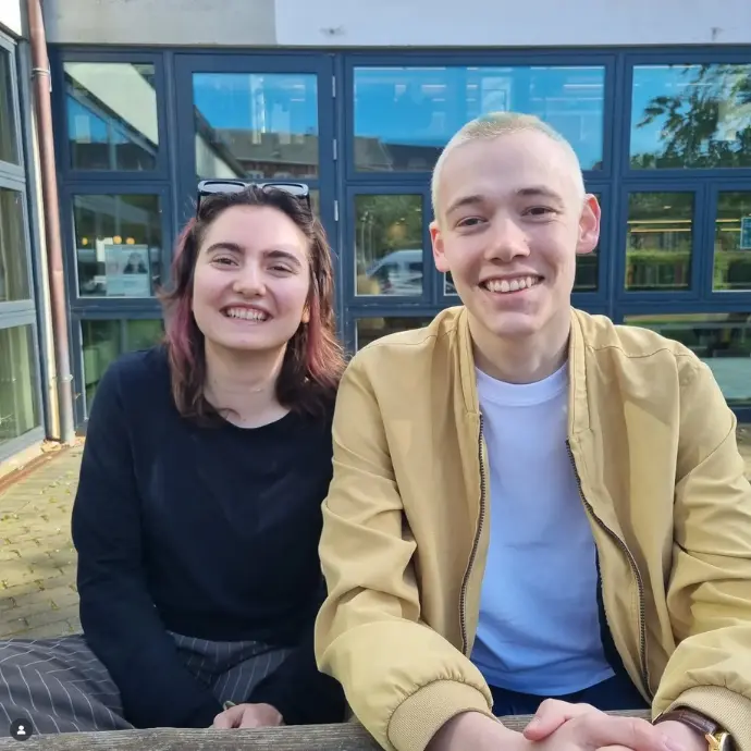 Billede af Noah og Sara der sidder sammen og smiler